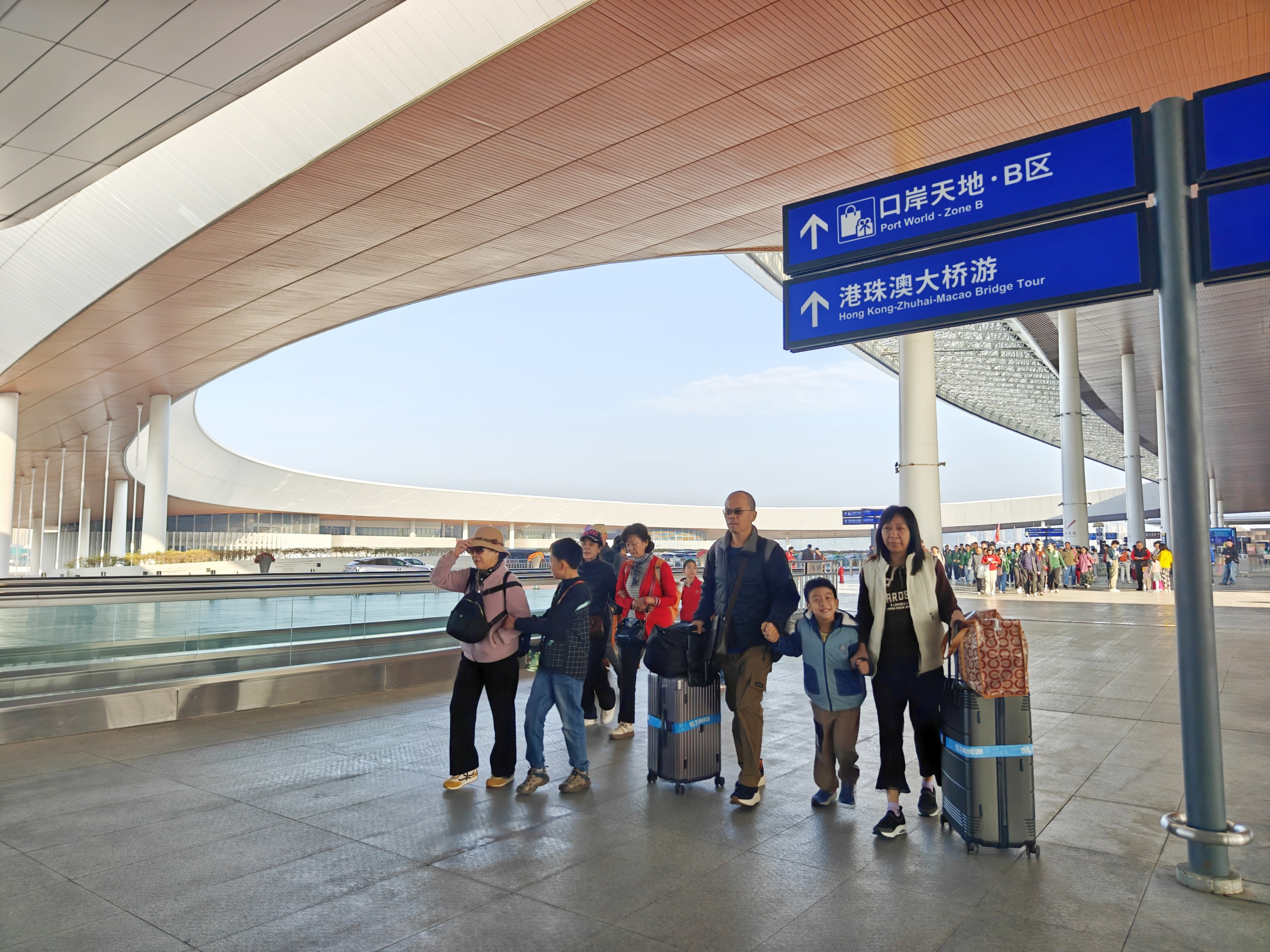 春运进行时，港珠澳大桥珠海公路口岸，旅客携亲友出行，准备出境前往澳门。人民网记者 王雅蝶摄